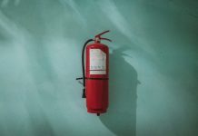 What’s Really Protecting Your Building? The Hidden Flaws In Fire Safety Most Owners Miss red fire extinguisher on green wall