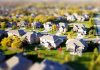 3 Ways a Property Manager Can Make Owning a Rental Property Less Scary Tilt-shift aerial photo of a suburban neighborhood with green lawns and roads.