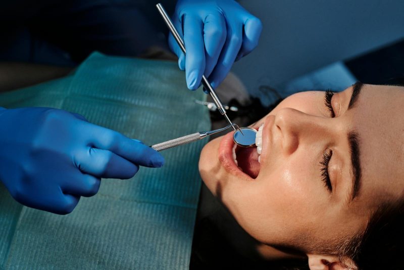 Photo by Cedric Fauntleroy Close-up of a dentist examining a patient's teeth using dental tools.
