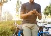 Built for the Moment: Why Aviator Games Are Winning with Simplicity man holding smartphone leaning on bicycle during daytime