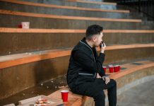 How a Walkie Talkie Offers Instant Group Communication Across the USA A security guard communicates via walkie-talkie while sitting in an empty arena.