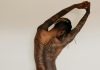 Explore Bold and Creative Tattoo Sleeve Designs man with body tattoos raising his right arm