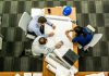Job Management Software That Actually Works Top view of a team working on construction plans in an office setting.