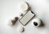 How Smart Home Devices Simplify Everyday Life Flat lay of smartphone and smart home devices on a white backdrop, showcasing modern technology.