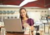 More Than Odds: How Platforms Keep Your Bets and Data Safe Woman enjoying remote work at a café, using a laptop and smartphone.