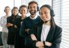 Real-Time Monitoring: A Key Benefit of Call Center Quality Assurance Software A diverse group of smiling call center agents in an office setting.