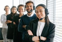 Real-Time Monitoring: A Key Benefit of Call Center Quality Assurance Software A diverse group of smiling call center agents in an office setting.