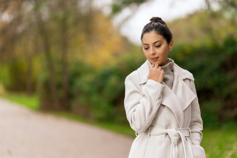 Photo by Liviu Boldis a woman in a white coat standing on a road