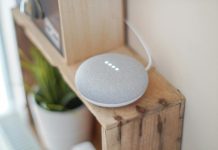 Smart Choices Digital Living and Everyday Value A Google Home Mini smart speaker on a wooden shelf, blending technology with home decor.