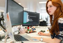 Top Cincinnati SEO Services: Agencies, Pricing & Results A focused female software engineer coding on dual monitors in a modern office.