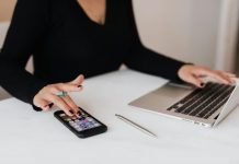 Why Forward-Thinking Brands Are Turning to Generative SEO A professional woman multitasking with a smartphone and laptop at an office desk.