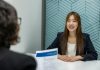 How to Network Like a Pro When You’re Job Hunting a woman sitting at a table with a piece of paper in front of her