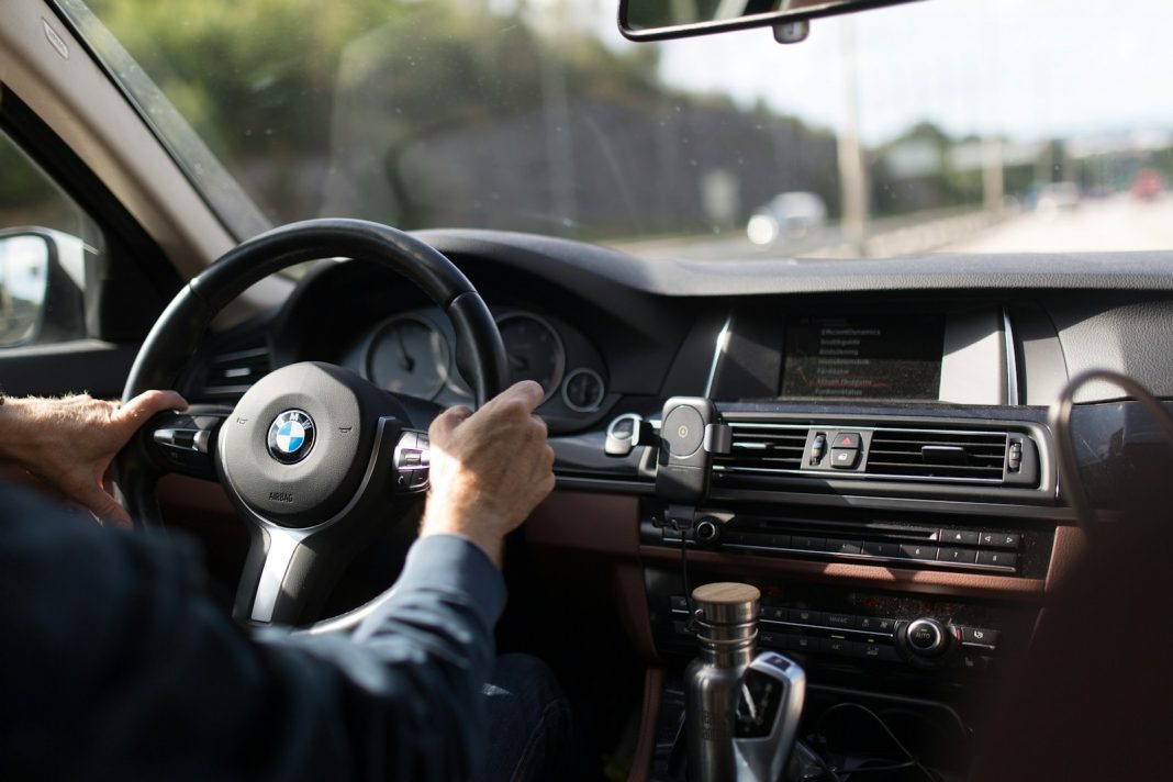 Photo by Bilderboken person holding BMW steering wheel