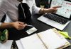 The Business Case for Smart Tech: How Investors Are Funding the Future of Real Estate A business professional working on real estate project plans using multiple devices in an office setting.