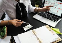 The Business Case for Smart Tech: How Investors Are Funding the Future of Real Estate A business professional working on real estate project plans using multiple devices in an office setting.