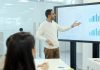 The future of sales departments: how AI is changing the sales analytics market Man presenting charts on a large screen.