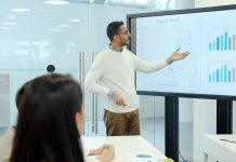 The future of sales departments: how AI is changing the sales analytics market Man presenting charts on a large screen.