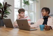 Helpful Tips for Managing a Remote Team man and woman sitting at table using macbook