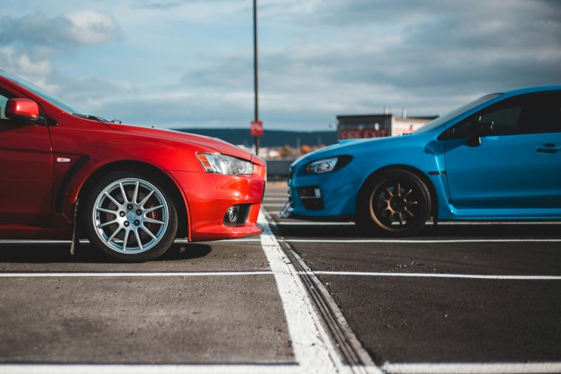 Photo by Erik Mclean blue and red cars in parking lots