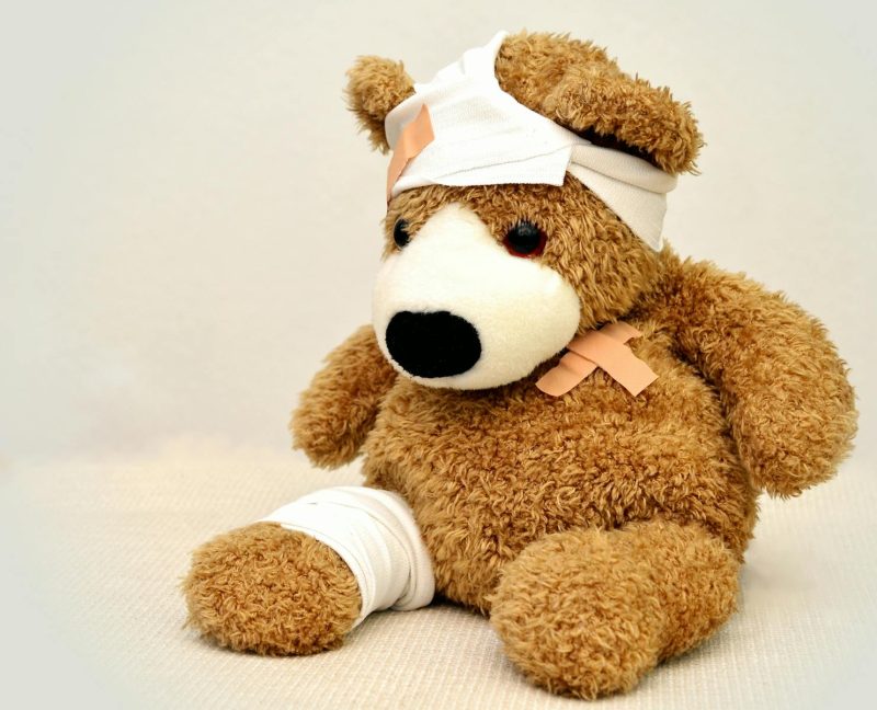 Photo by Pixabay A brown teddy bear with bandages, depicting a playful take on injury recovery in a minimalist setting.