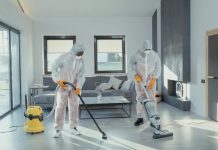 Simple Home Maintenance Tips That Save You from Costly Repairs Two workers in protective gear vacuum and disinfect a modern living room.