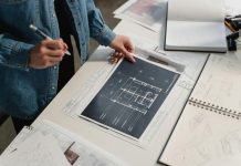 Turning Data into Deals: How Analytics Are Powering the Future of Commercial Real Estate Marketing Engineer reviewing architectural blueprints on a desk with technical drawings.