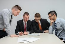 Why More First-Time Investors Are Choosing to Open a Demat Account With Trusted Brokers four men looking to the paper on table