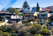 A Complete Guide to Property Investment in Australia Modern houses on a lush, green hillside.