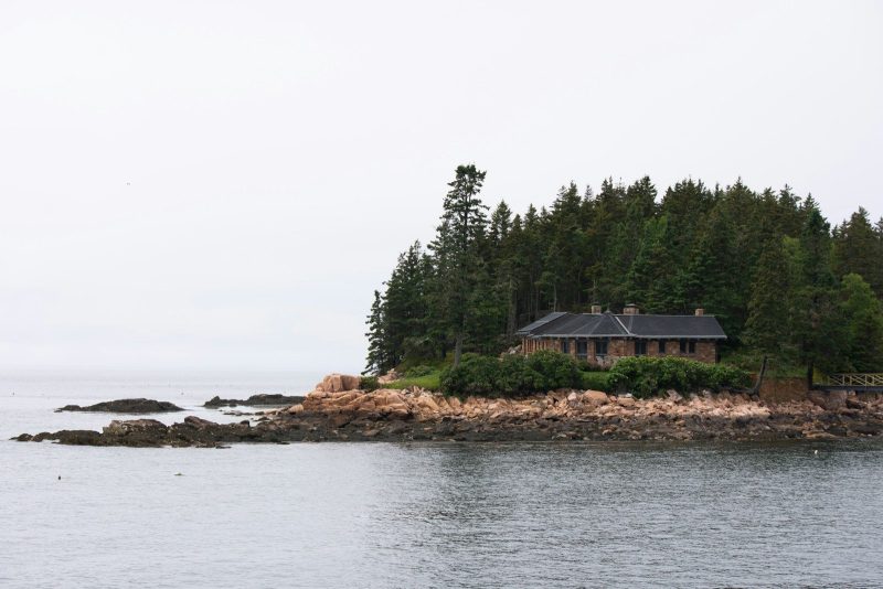 Photo by Donovan Reeves A house sits on a rocky, forested island.