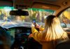 a woman driving a car with a cell phone in her hand