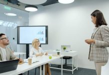 Slimme enterprise data platform oplossingen door Crystalloids Woman presenting to colleagues in a modern office meeting.