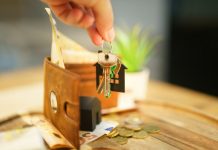 How Much Should You Set Aside for Repairs as a Landlord? Hand holding keys with house charm and wallet.
