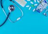 a stethoscope, pills, and a shopping cart on a blue background