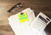 Calculator, glasses, and papers with 'now hiring' note.