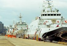 How Maritime Lawyers Can Distinguish Themselves Via Marketing Several white ships docked at a harbor with city skyline.