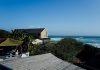 How to Maintain and Maximise Returns on Your Coastal Rental Property Coastal homes overlooking the ocean with lush green trees.