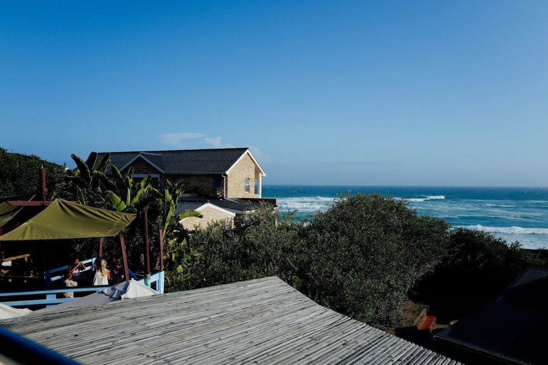 Coastal homes overlooking the ocean with lush green trees.