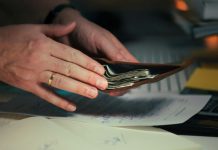 How Does a Bank Overdraft Facility Provide Instant Financial Support? Hands holding cash in a wallet over papers.