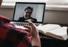 person in red and black plaid long sleeve shirt using black laptop computer