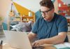 Space Management Strategies for Scaling a Home-Based Business Man working on a laptop at a desk.