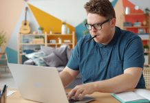 Space Management Strategies for Scaling a Home-Based Business Man working on a laptop at a desk.