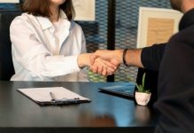 How Feedback from Mock Interviews Improves IBPS PO Interview Performance a man and a woman shaking hands in front of a laptop