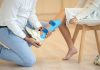 Essential Injury Prevention Strategies and Gear for Contact Sports a man sitting on a chair holding a blue object