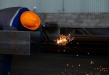 What Workplace Injury Data Really Says About Small Business Risk a man wearing a hard hat working on a piece of metal