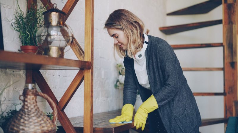 Photo by Vitaly Gariev Woman wearing yellow gloves cleaning wooden surface