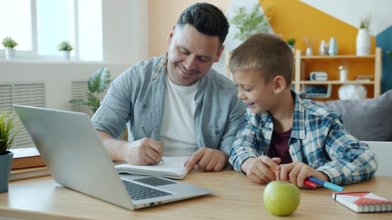 Photo by Vitaly Gariev Father and son studying together at a desk