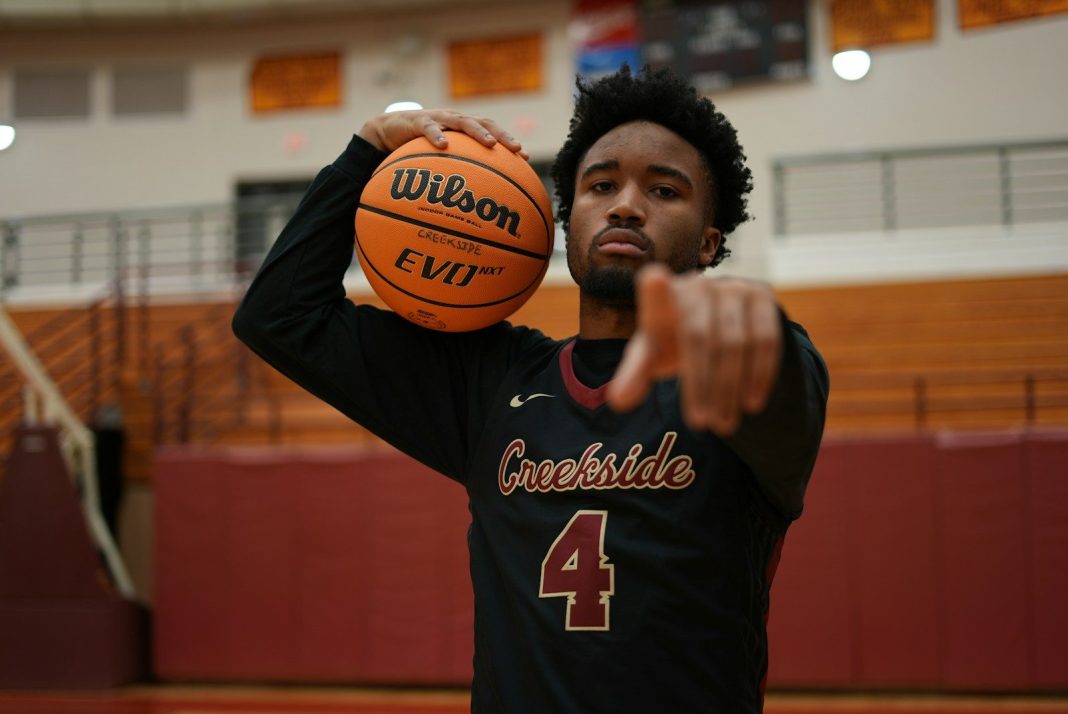 Photo by Anthony McKissic a man holding a basketball in a gym
