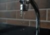 Why Does My Small Business Water Bill Keep Going Up When Nothing Has Changed? a faucet with water running from it's spout