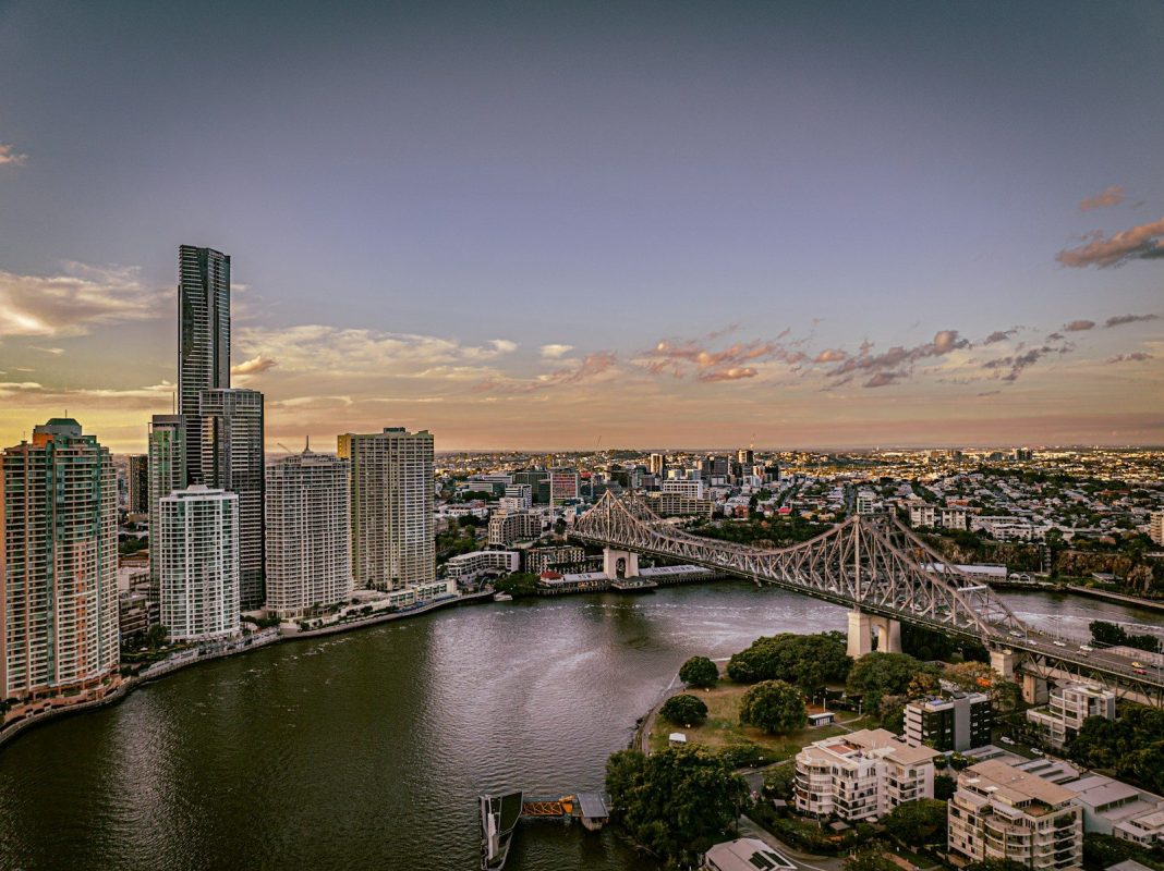Photo by Josh Withers a bridge over a river with a city in the background