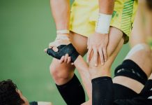 Why Weekend Warriors Need to Prioritise Knee Health man helping another on stand up
